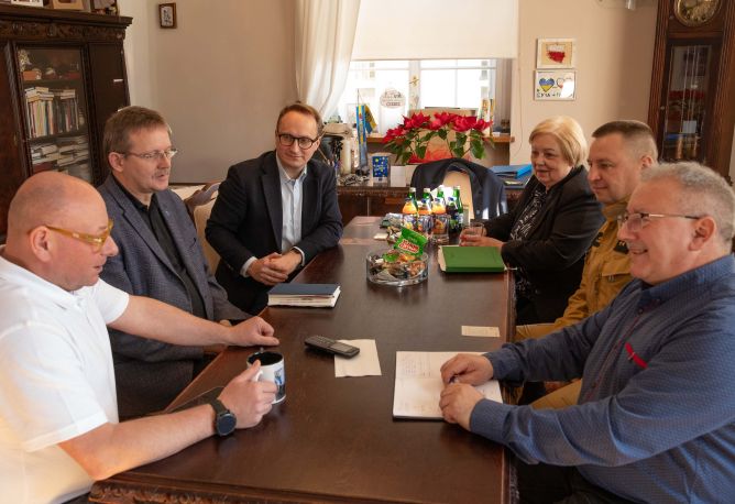 Burmistrz wraz z urzędnikami podczas rozmowy z przedstawicielami Ochotniczej Straży Pożarnej przy stole