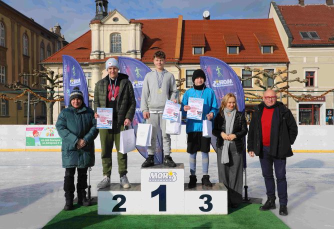 Burmistrz, zastępca burmistrza, dyrektor Miejskiego Ośrodka Rekreacji i Sportu wręczają nagrody zawodnikom podczas zawodów łyżwiarskich na lodowisku