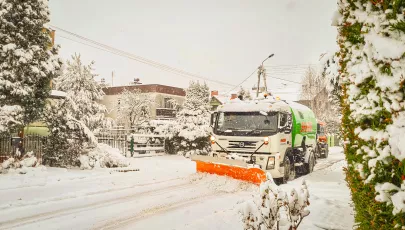 pług jadący po zaśnieżonej ulicy