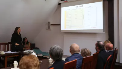 grupa ludzi słuchająca prezentacji podczas spotkania
