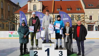 Burmistrz, zastępca burmistrza, dyrektor Miejskiego Ośrodka Rekreacji i Sportu wręczają nagrody zawodnikom podczas zawodów łyżwiarskich na lodowisku